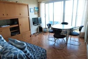 a living room with a table and chairs and a tv at Appartement VUE MER 4 personnes au centre de TREGASTEL - Ref 95 in Trégastel