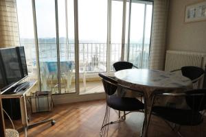 a room with a table and chairs and a large window at Appartement VUE MER 4 personnes au centre de TREGASTEL - Ref 95 in Trégastel