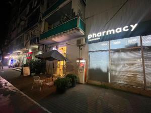 a store with an umbrella on a street at night at Cozy Newly Renovated Apartment in Batumi Old Town in Batumi
