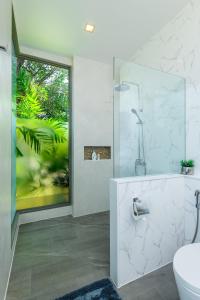 a bathroom with a glass shower and a toilet at Villa Mimosa 1, Splendid 4 Bedroom Master Ensuite in Phuket Town