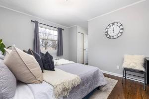 ein Schlafzimmer mit einem Bett und einer Uhr an der Wand in der Unterkunft Queen Bed Apt in West Hartford in West Hartford