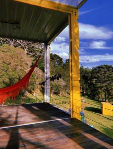 una porta aperta su un portico con amaca di Refugio do Capivari a Represa Capivari