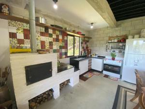 una cucina con camino al centro di Refugio do Capivari a Represa Capivari Altre 15 foto