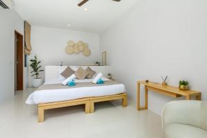 a white bedroom with a bed and a desk at Villa Mimosa 1, Splendid 4 Bedroom Master Ensuite in Phuket Town