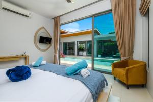 a bedroom with a bed and a swimming pool at Villa Mimosa 1, Splendid 4 Bedroom Master Ensuite in Phuket Town +37 photos