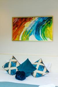 a painting above a bed with pillows on it at Villa Mimosa 1, Splendid 4 Bedroom Master Ensuite in Phuket Town