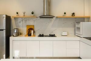 a kitchen with white cabinets and a counter top at Villa Mimosa 1, Splendid 4 Bedroom Master Ensuite in Phuket Town
