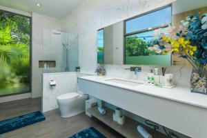 a bathroom with a sink and a toilet and a mirror at Villa Mimosa 1, Splendid 4 Bedroom Master Ensuite in Phuket Town