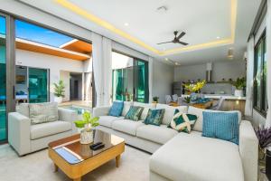 a living room with white furniture and a ceiling fan at Villa Mimosa 1, Splendid 4 Bedroom Master Ensuite in Phuket Town