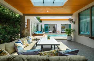 a living room with a couch and a table at Villa Mimosa 1, Splendid 4 Bedroom Master Ensuite in Phuket Town
