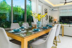 a dining room with a table and white chairs at Villa Mimosa 1, Splendid 4 Bedroom Master Ensuite in Phuket Town