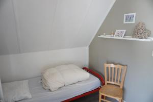 a bed in a room with a wooden chair at Kustverhuur, Park Schoneveld Stern 253 in Breskens