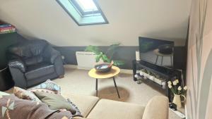 a living room with a couch and a tv at Rosie's Apartments in Killybegs