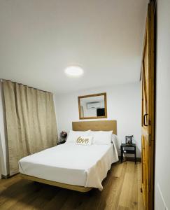 a bedroom with a bed with a love pillow on it at Libertad B in Santiponce