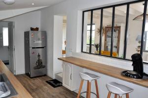 a kitchen with a counter and a refrigerator and stools at Maison de charme 3 étoiles avec jardin clos terrasse PERROS-GUIREC - ref 869 in Perros-Guirec