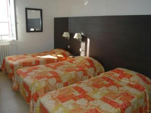 a hotel room with two beds and a mirror at Hôtel Lassus in Bolquere Pyrenees 2000