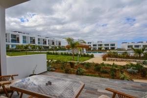 a balcony with a table and chairs and buildings at Deja Blue Apartment Cyprus in Bahçeli