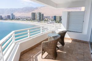 a balcony with a table and chairs and the ocean at Terrado Suites Iquique in Iquique