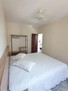 a bedroom with a large white bed with a ceiling at Cabo Frio apartamento Casa Mar in Cabo Frio