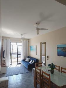 a living room with a blue couch and a table at Cabo Frio apartamento Casa Mar in Cabo Frio