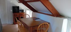 a dining room with a wooden table and chairs at The Old Granary in Whitland