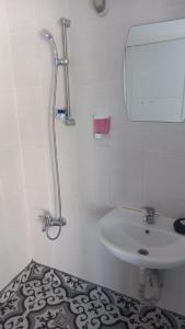 a white bathroom with a sink and a mirror at Paradise Hotel Akcay in Edremit