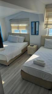 a bedroom with two beds and a mirror at Paradise Hotel Akcay in Edremit