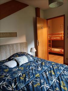 una camera da letto con un letto con una coperta blu di Appartement GERARDMER - Magnifique vue sur le lac - jusqu'à 4 personnes a Gérardmer