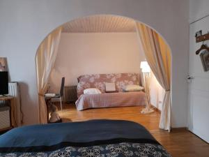 a bedroom with a bed with an archway in it at Maison COLETTE in Villardonnel