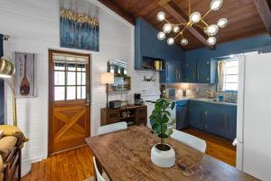 eine Küche mit blauen Schränken und einem Tisch mit einer Pflanze in der Unterkunft Emerald Cove Lakefront Cabin With Kayaks & Canoes in Shreveport + 55 Fotos