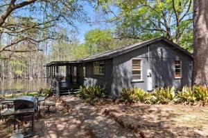 Una pequeña casa en el bosque junto a un lago. en Emerald Cove Lakefront Cabin With Kayaks & Canoes, en Shreveport
