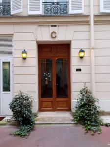 a wooden door on a building with two bushes at Backpacker room with an Eiffel Tower view near St Germain des Prés in Paris