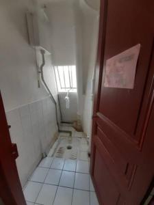 a small bathroom with a window and a tiled floor at Backpacker room with an Eiffel Tower view near St Germain des Prés in Paris