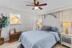 a bedroom with a bed and a ceiling fan at Charming Ivy Street House With Porch Swing in Mooringsport