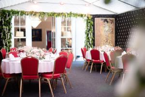 a dining room with tables and red chairs at Stone Court House in Maidstone