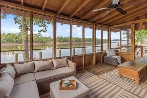 a living room with a couch and a table at 2 Mi To Casinos, Red River Lodge, River Views in Shreveport