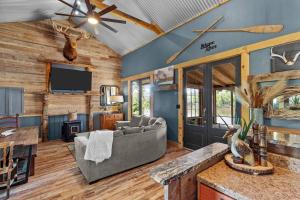 a living room with a couch and a tv at 2 Mi To Casinos, Red River Lodge, River Views in Shreveport