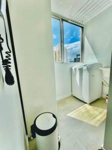 a white room with a trash can and a window at Apto Aconchegante em Floripa in Florianópolis +15 photos