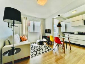 a kitchen and living room with a table and chairs at Apto Aconchegante em Floripa in Florianópolis