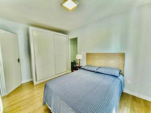 a bedroom with a bed with a blue comforter at Apto Aconchegante em Floripa in Florianópolis