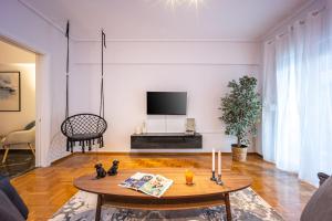 アテネにあるPagrati Luxuryのテーブルとテレビのあるリビングルーム