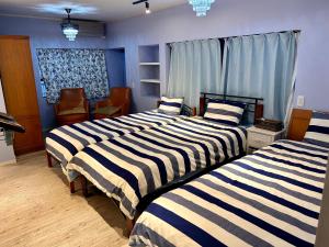 two beds in a room with blue walls at 若狭の家 in Naha