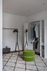 une chambre avec un pouf vert et un placard dans l'établissement Stylowy Apartament w centrum Piecowy Zakątek, à Przemyśl
