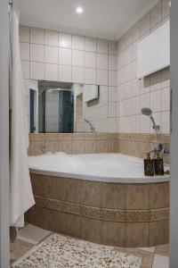 une salle de bain avec une baignoire et un miroir dans l'établissement Stylowy Apartament w centrum Piecowy Zakątek, à Przemyśl