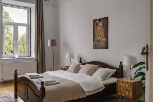 une chambre avec un lit avec des draps blancs et une fenêtre dans l'établissement Stylowy Apartament w centrum Piecowy Zakątek, à Przemyśl