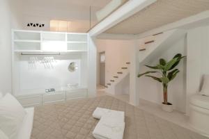 une salle de bains blanche avec des toilettes et une plante en pot dans l'établissement Ortygia Suites, à Mykonos 81 autres photos