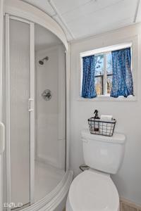 a bathroom with a toilet and a shower and a window at Shipwreck with upper deck, Dock Access, Kayaks in Karnack +39 photos