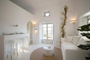 a white living room with a white couch and a table at Ortygia Suites in Mikonos