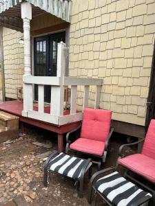 two chairs and a bench on the porch of a house at River View, Red River Carriage House in Shreveport