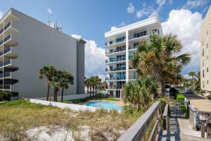 a building with a swimming pool and palm trees at Dune Pointe 201 in Fort Walton Beach